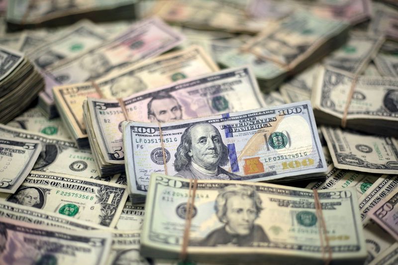 Dollar hovers near one-week low as Evergrande questions persist
